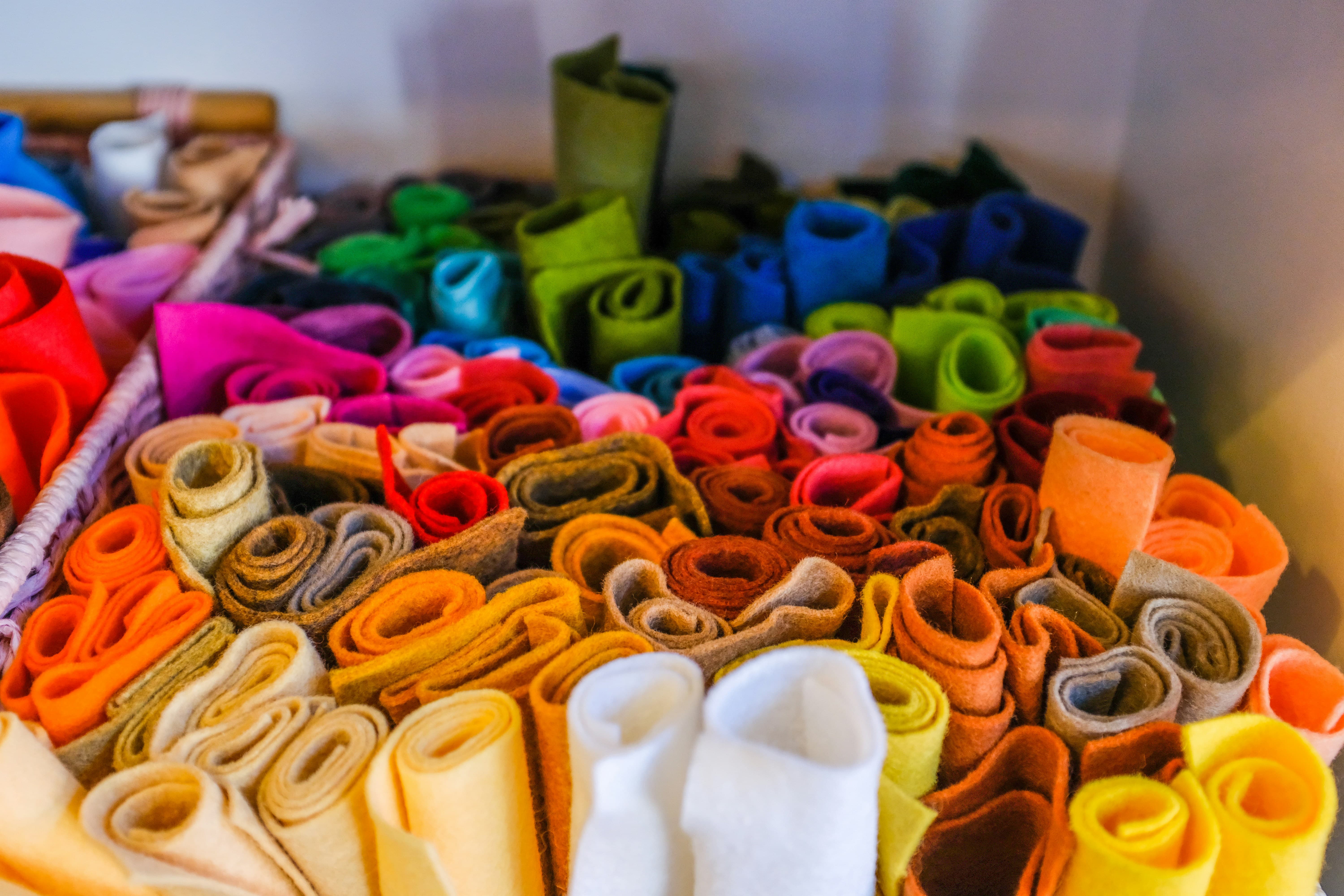 Rolls of multicolour felt material stacked together.